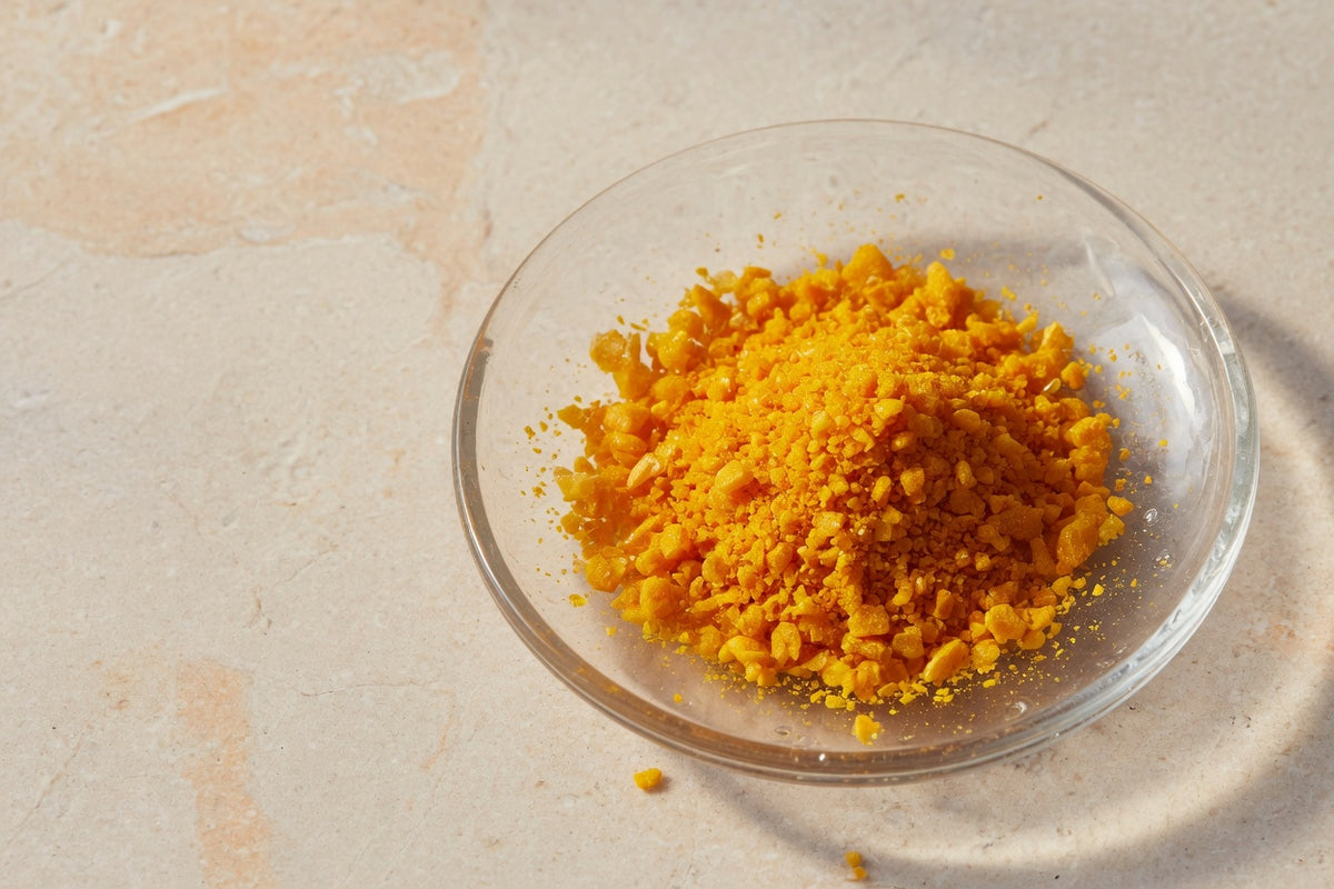 Bright yellow-orange coenzyme crystals in a glass dish.